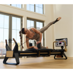 woman using NordicTrack Ultra 1 Reformer in home with 24" pivoting touchscreen for video instruction